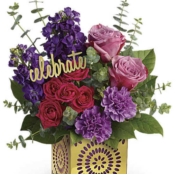 Mixed pink, purple, and red roses in a decorative yellow box with a "celebrate" sign