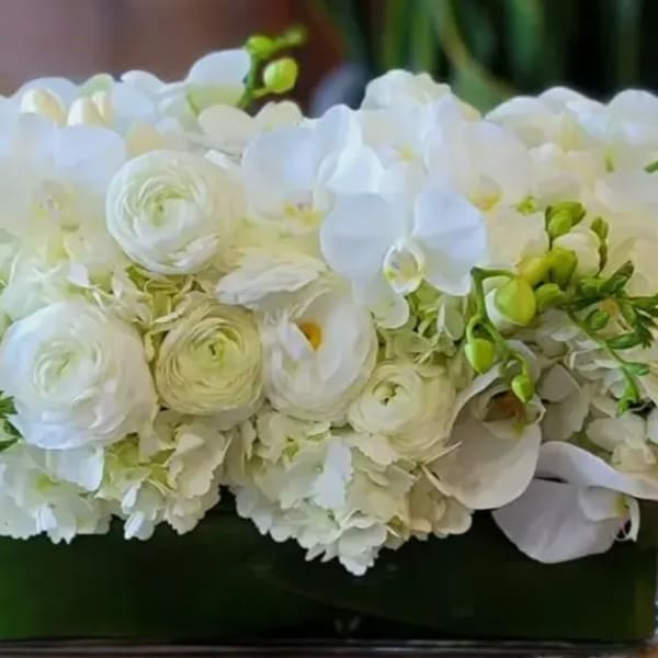 White floral arrangement in a rectangular glass vase