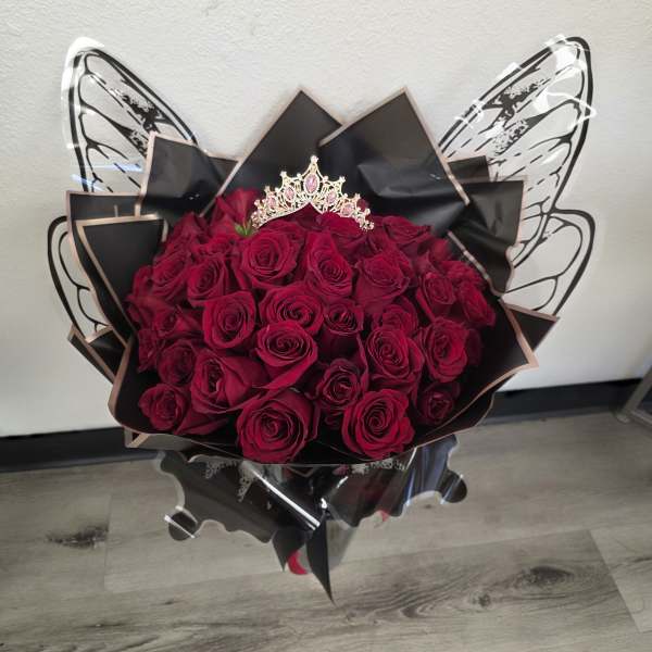 Bouquet of deep red roses with a jeweled crown topper and black wrap