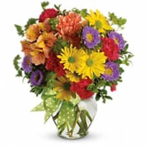 Colorful mixed bouquet in a clear glass vase with a green polka-dot ribbon