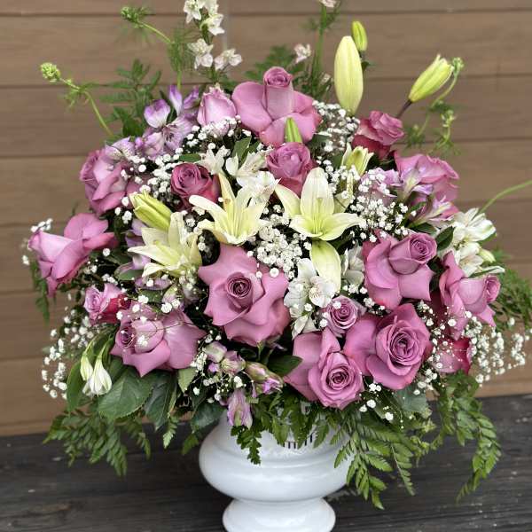 Pink roses and white lilies in a white vase