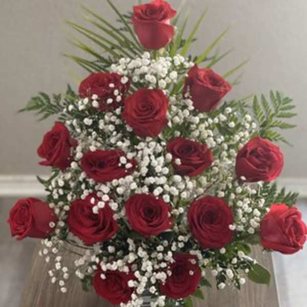 Red roses arranged with baby's breath in a vase