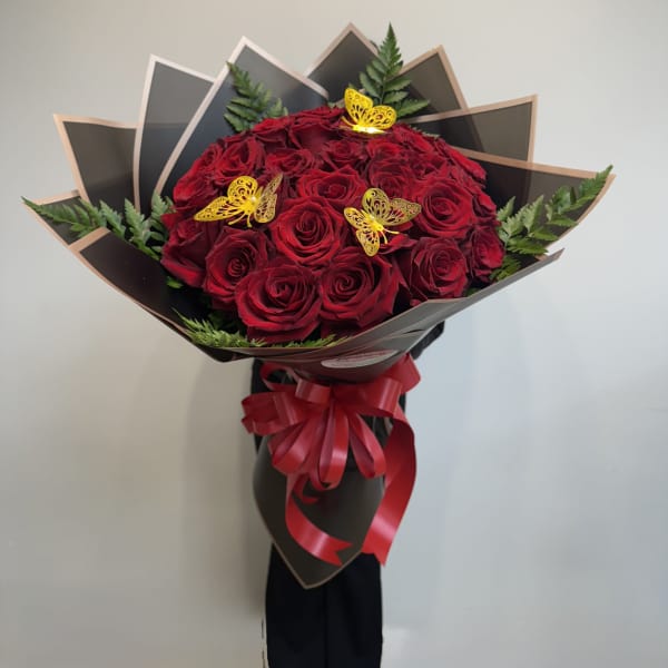 Bouquet of red roses with butterfly picks and a red ribbon