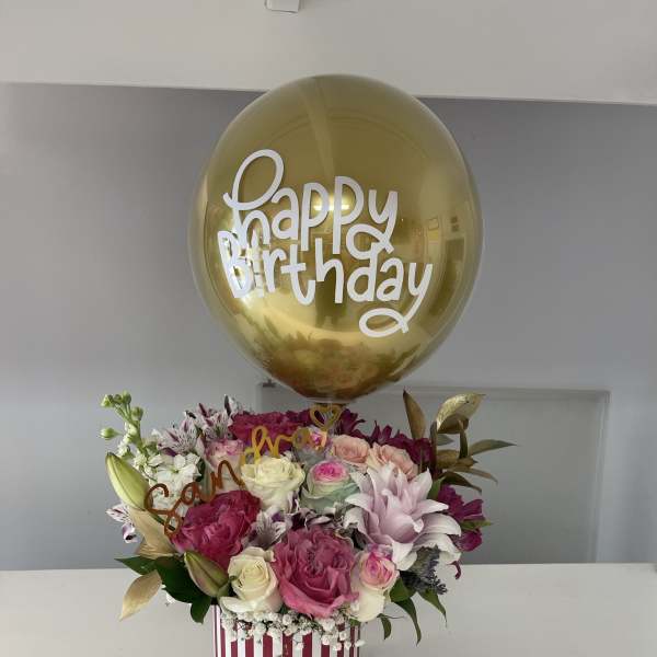 Birthday bouquet with pink and white roses under a gold balloon