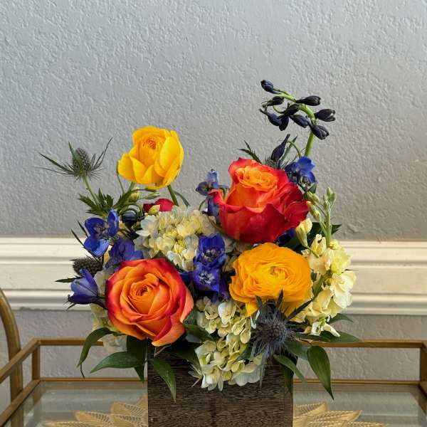 Colorful rose arrangement in a square wooden vase