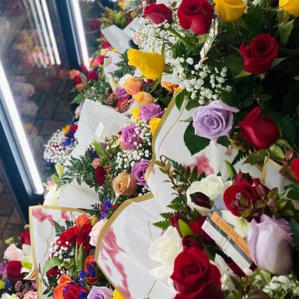 Rows of colorful rose bouquets wrapped in white paper