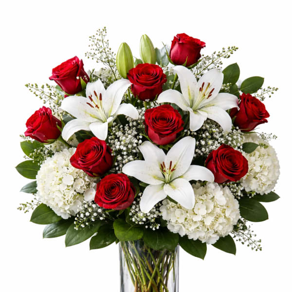Red roses and white lilies in a clear glass vase