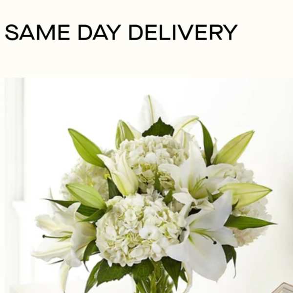 White lilies and hydrangeas in a clear glass vase