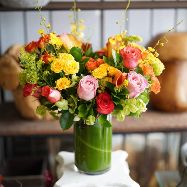 Colorful rose bouquet in a tall glass vase