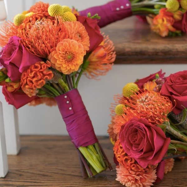 Two pink and orange bridal bouquets with roses and mums