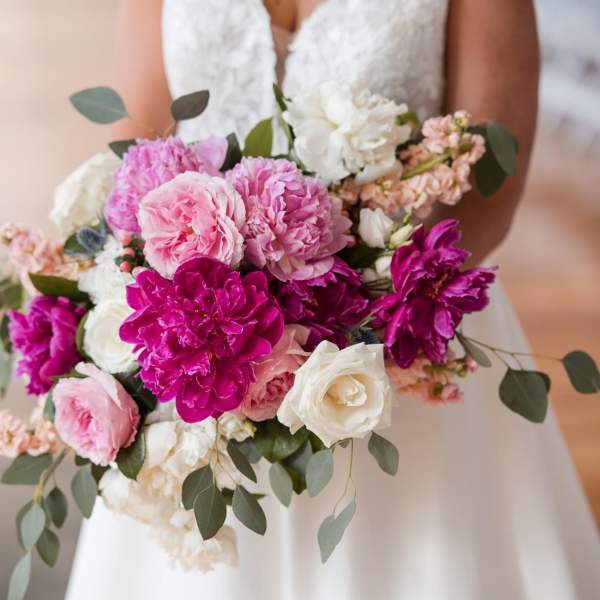 Bride holding a bouquet of pink, magenta, and white flowers