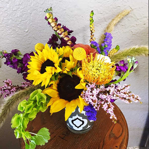 Bright mixed bouquet with sunflowers in a patterned vase