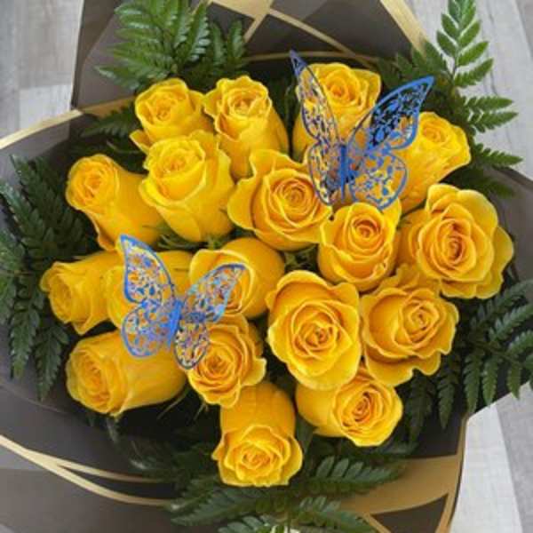 Bouquet of yellow roses with fern foliage and butterfly picks