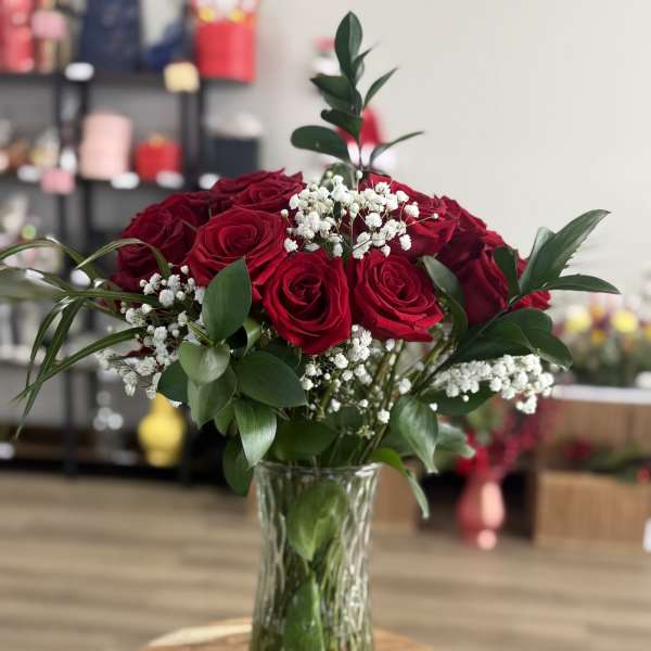 Red roses in a clear glass vase with white baby's breath