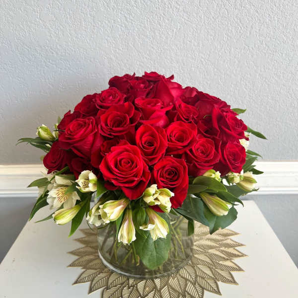 Red roses and white alstroemeria in a clear glass vase