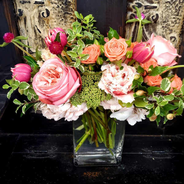 Pink and peach roses arranged in a clear glass vase