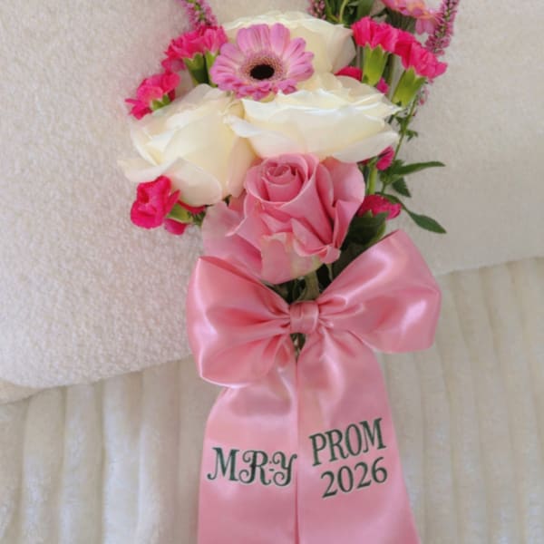 Pink and white prom corsage with roses, gerbera daisy, and a satin bow