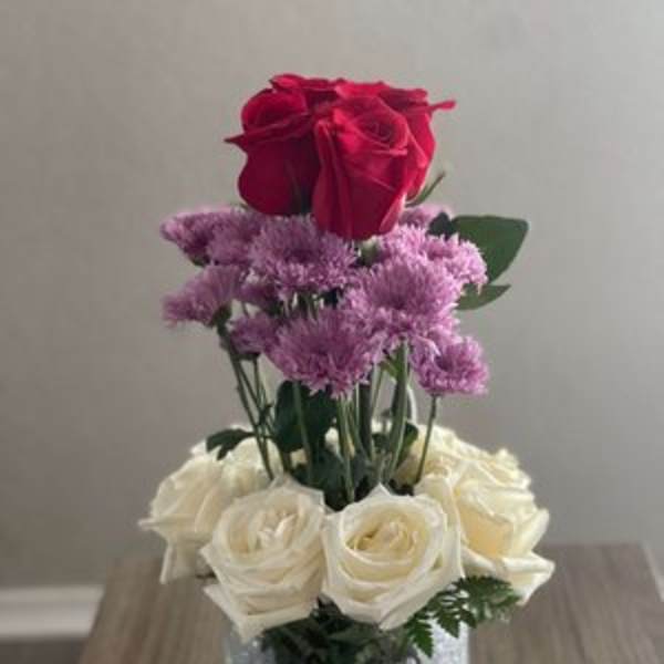 Red and white roses arranged in a glittery glass vase