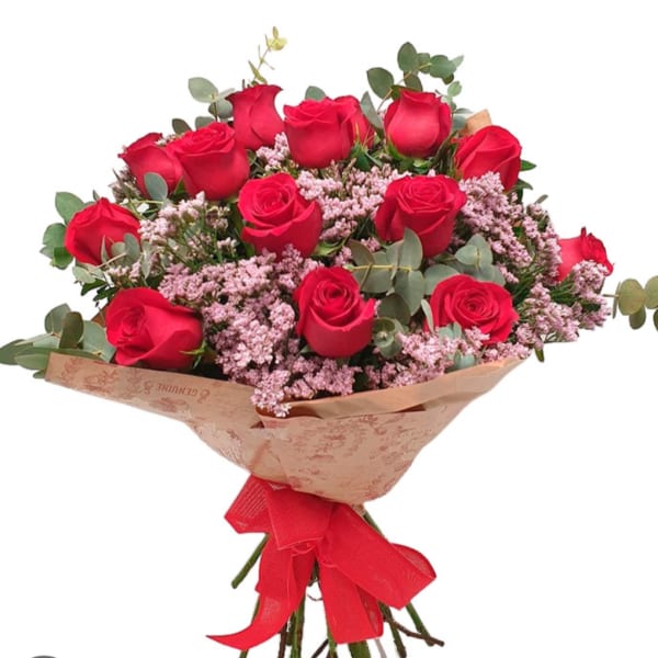 Bouquet of red roses with pink filler flowers and a red ribbon