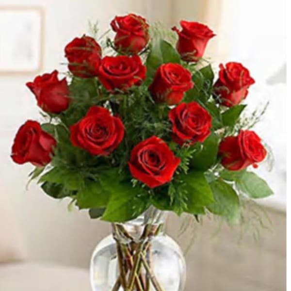 Red roses arranged in a clear glass vase