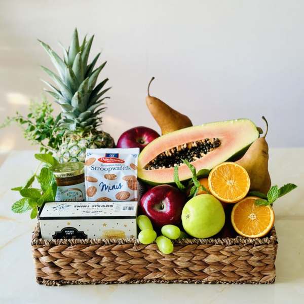Fruit gift basket with pineapple, pears, oranges, apples, grapes, and snacks