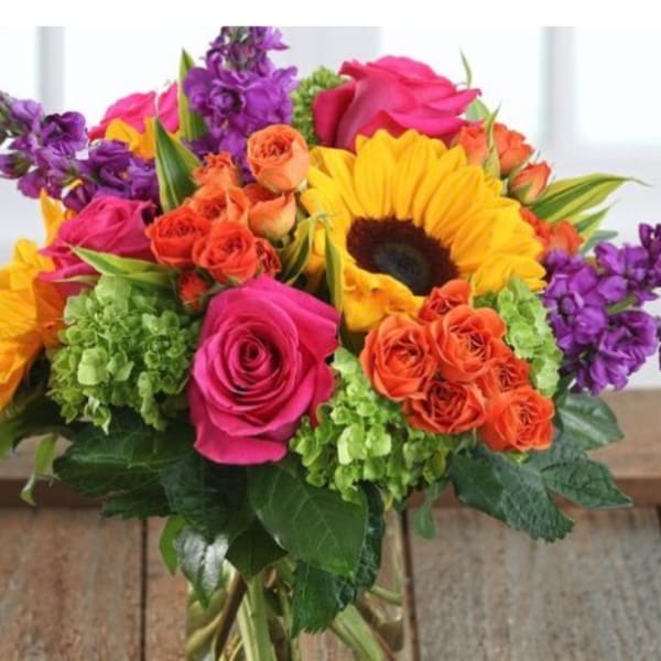 Bright mixed bouquet with roses, sunflowers, and purple blooms