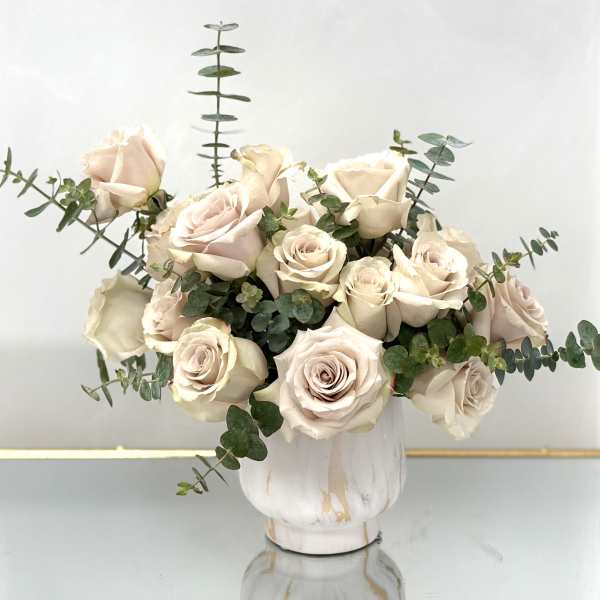 Cream rose bouquet in a white vase with eucalyptus