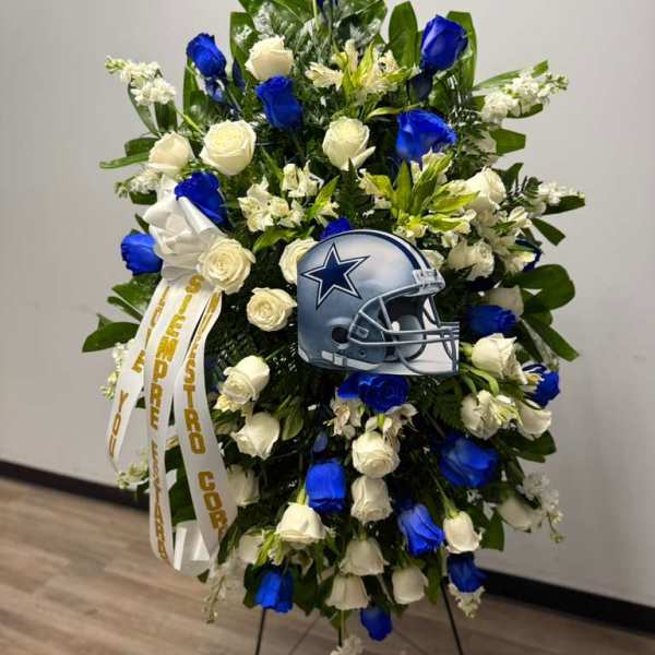 Standing floral wreath with blue and white roses and a football helmet tribute