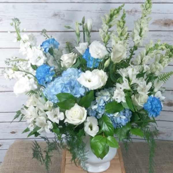 Blue and white floral arrangement in a white vase