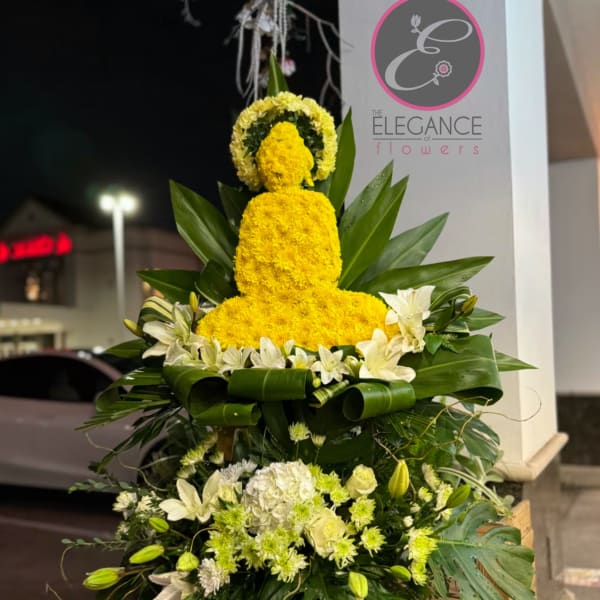 Tall yellow floral tribute with white flowers and broad green leaves