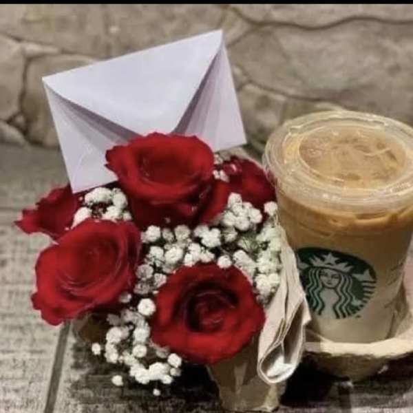 Small bouquet of red roses with baby's breath beside an iced Starbucks drink