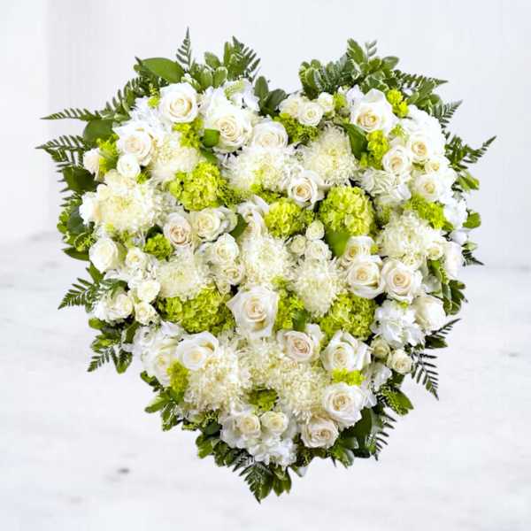 Heart-shaped floral arrangement of white roses and green hydrangeas