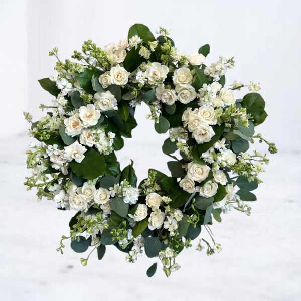 White flower wreath with cream spray roses and small white blooms in a circular design
