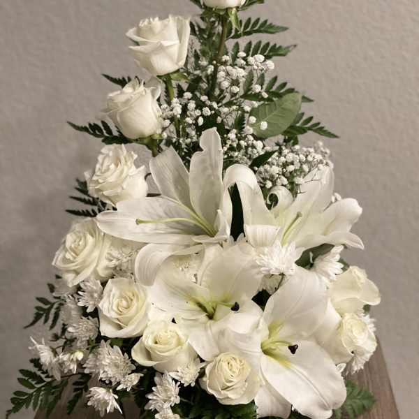 White roses and lilies arranged in a triangular bouquet