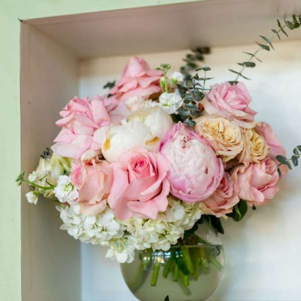Pink and white flower arrangement in a round glass vase