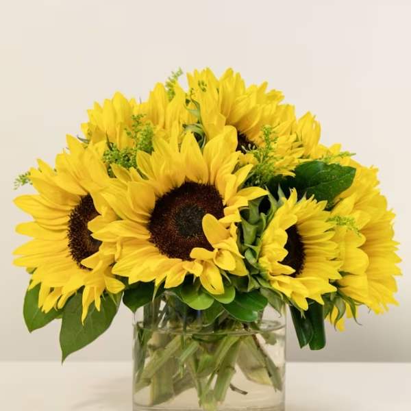 Bouquet of yellow sunflowers in a clear glass vase