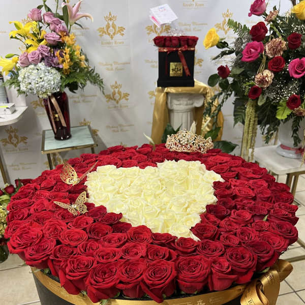 Heart-shaped rose arrangement in a black box with red and white roses