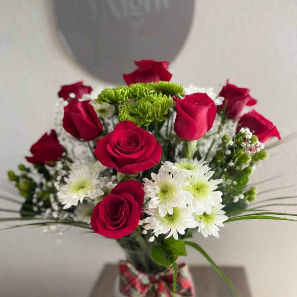 Bouquet of red roses and white daisies in a glass vase