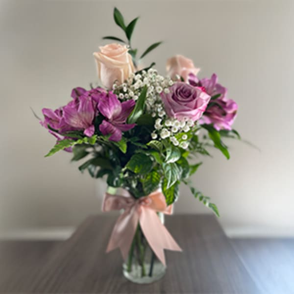Pink and purple bouquet with roses in a clear glass vase