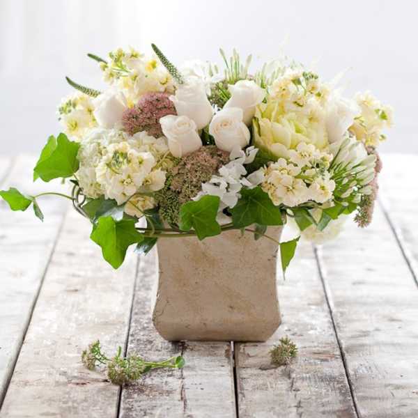 White floral arrangement in a square beige vase
