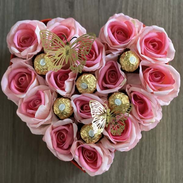 Heart-shaped box of pink roses with gold-wrapped chocolates and butterfly picks