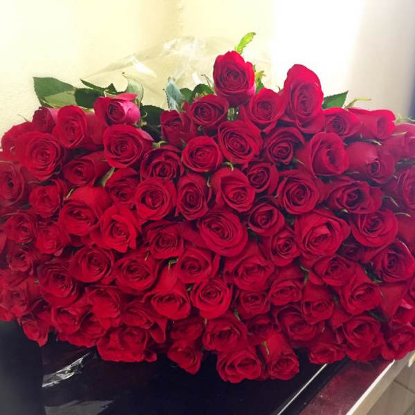 Large bouquet of red roses with a few green leaves