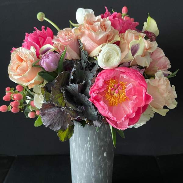 Pink and peach floral bouquet in a tall vase