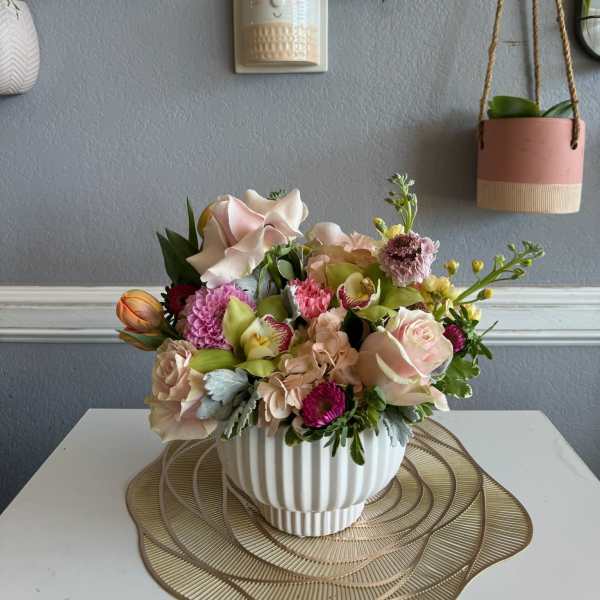 Mixed pastel flower arrangement in a white ribbed vase