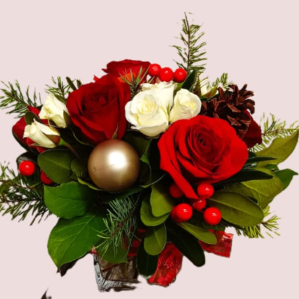 Bouquet of red and white roses with holiday berries and a gold ornament