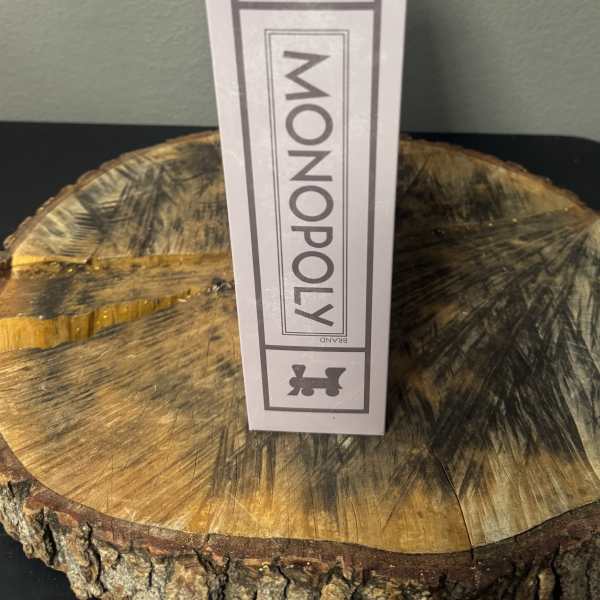 White Monopoly Vintage Bookshelf Edition box standing on a wood slice