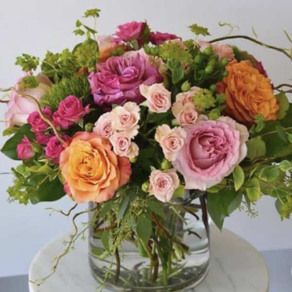 Mixed pink and orange roses in a clear glass vase