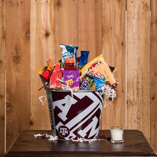 Texas A&M gift bucket filled with assorted snacks and a candle