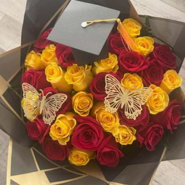Bouquet of red and yellow roses with butterfly decorations and a graduation cap