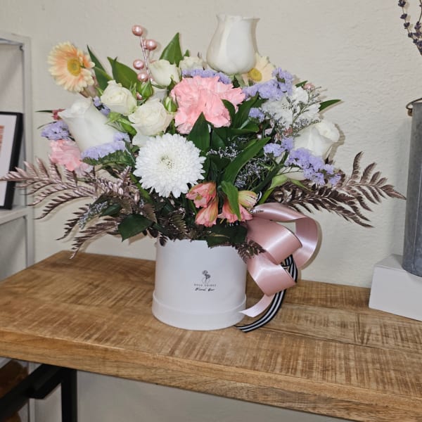 Mixed pastel bouquet in a white hatbox with a pink ribbon